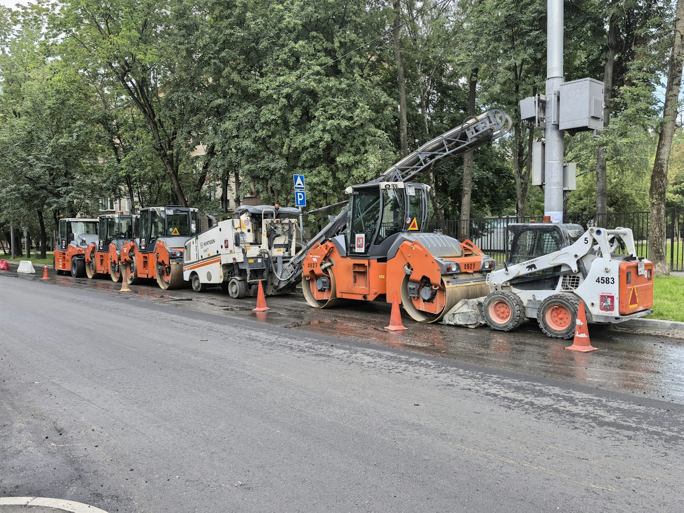 Wegenbouwmaterieel op nat asfalt in een straat